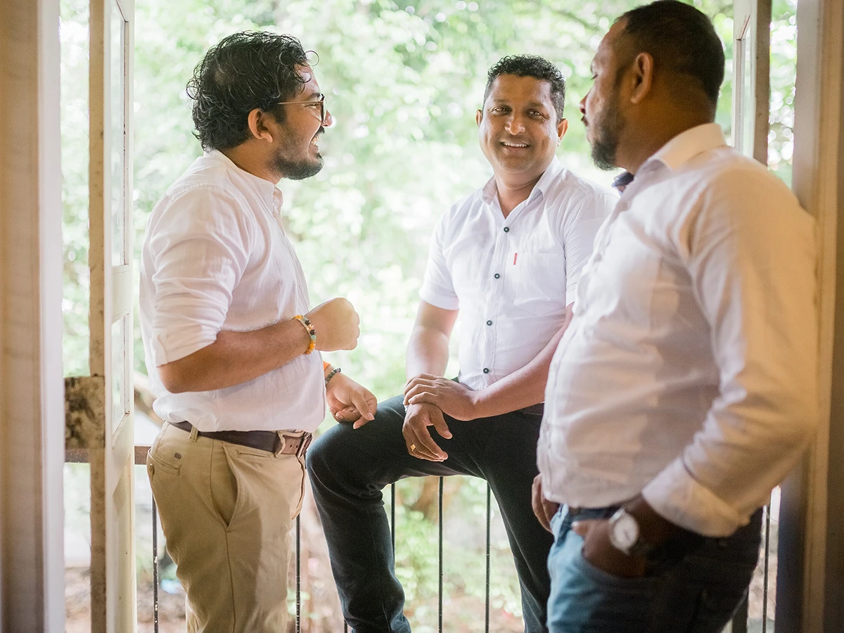 Three of the team talking by an open window
