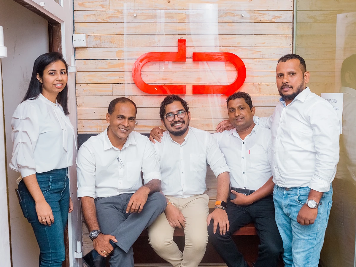 The Design Republic team in front of the studio’s red logo