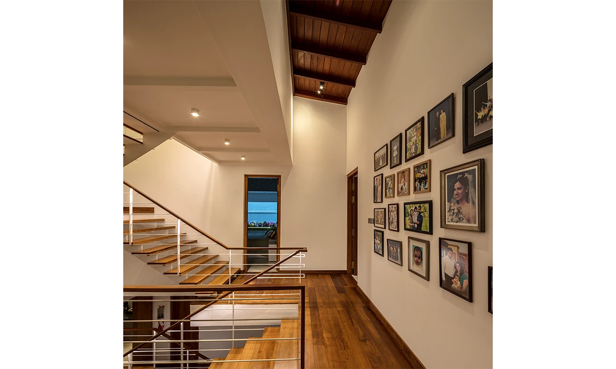 Timber stair and landing lined with framed photographs