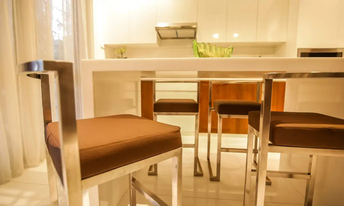 Breakfast counter with leather stools in the white kitchen