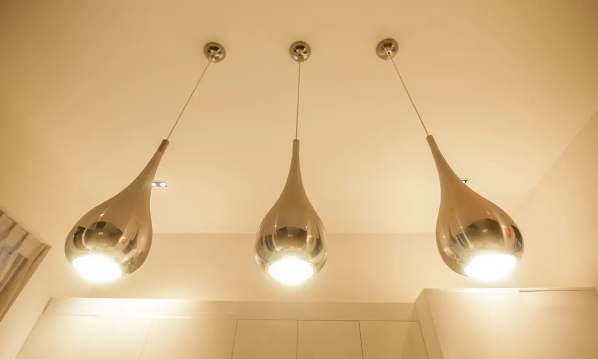 Three chrome teardrop pendants over the kitchen counter