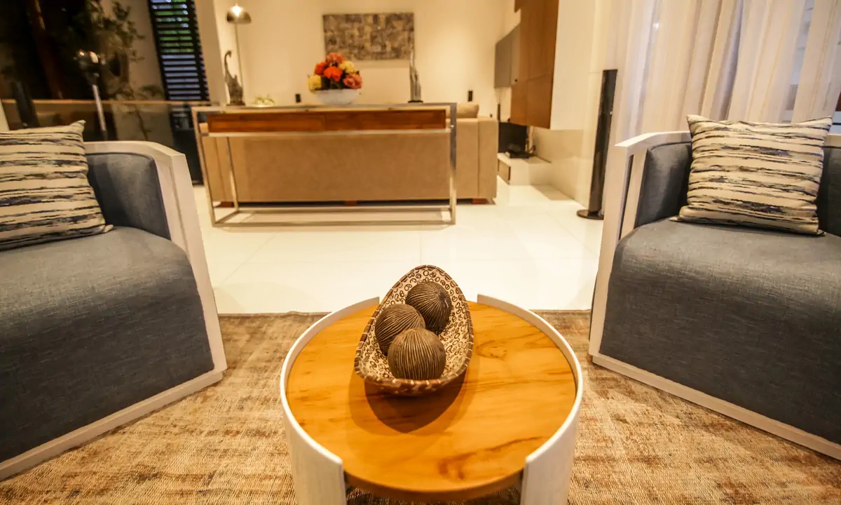 Grey armchairs around a round timber coffee table in the living room