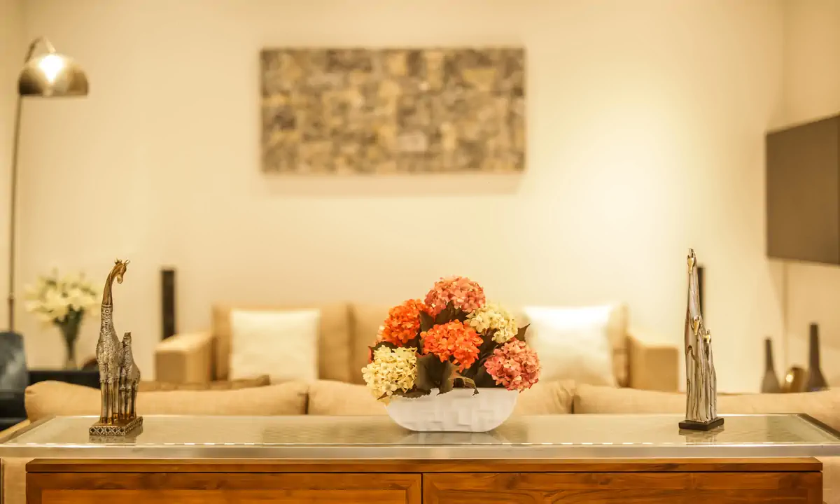 Timber console with flowers in front of the living room sofa