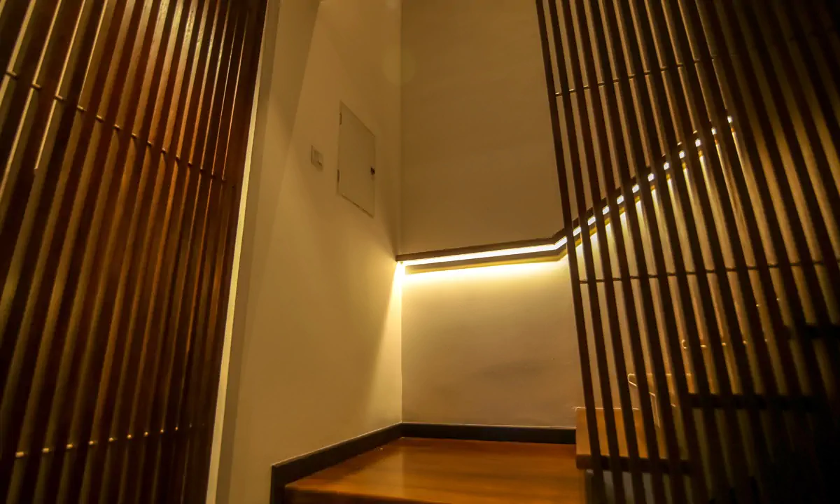 Stair landing wrapped in vertical timber slats with concealed lighting