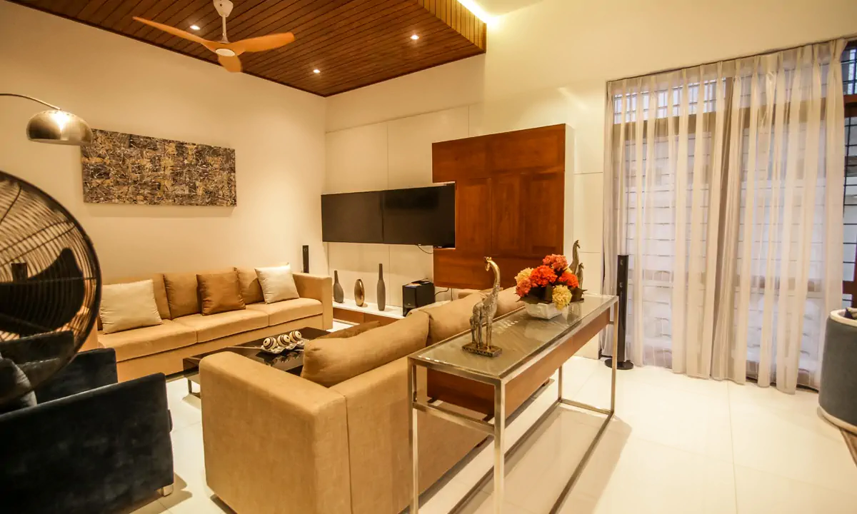 Family room with beige sofas under a timber-lined ceiling and a ceiling fan