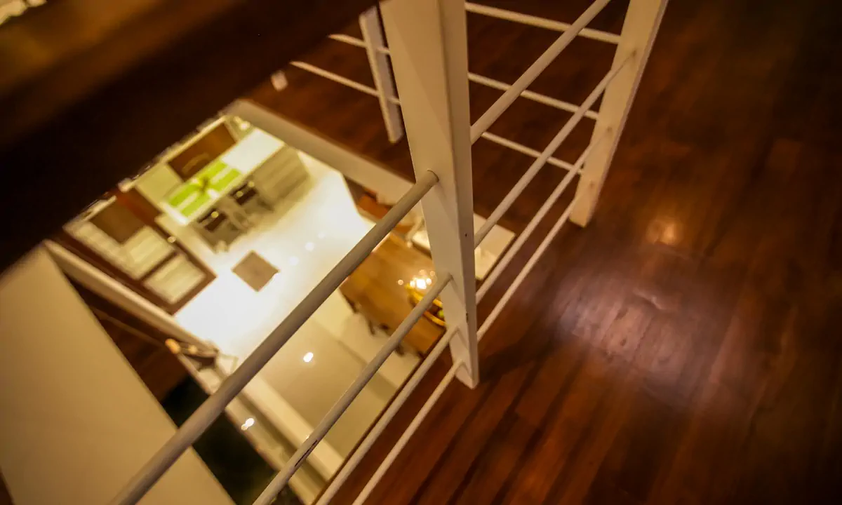 Looking down over the timber floor and balustrade to the kitchen below