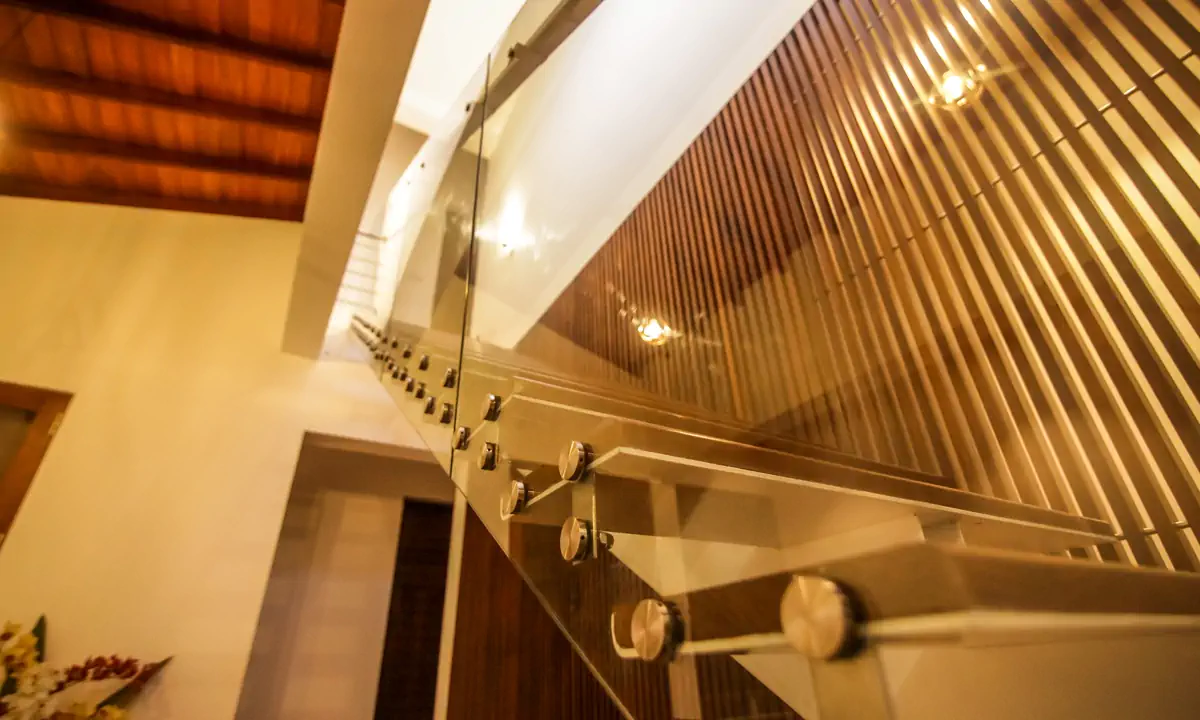 Glass balustrade and timber slats along the stair under the pitched ceiling