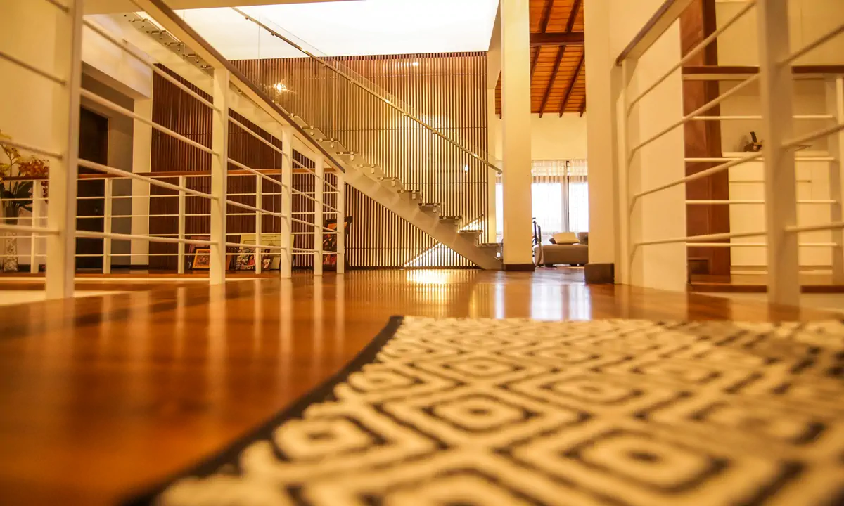 Top-floor landing with a timber floor, a patterned rug and white balustrades