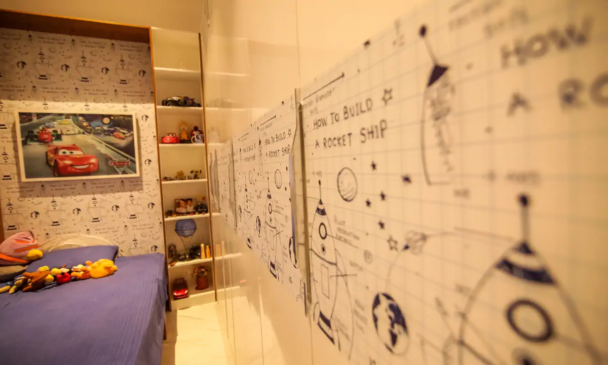 Child’s bedroom with rocket-ship wallpaper and shelves of toys