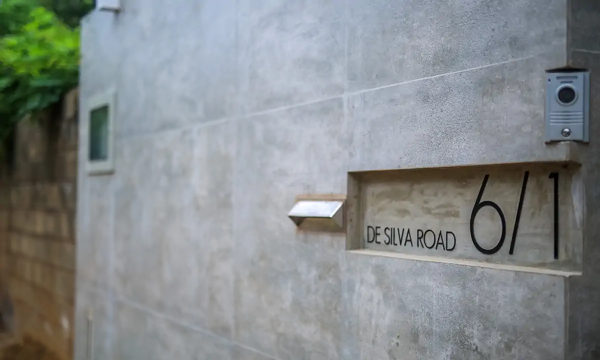 Board-marked concrete gate pillar with an entryphone