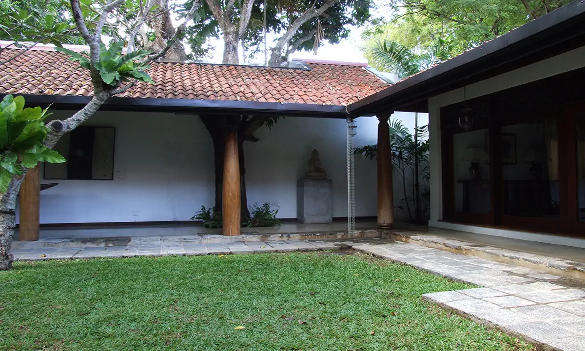Lawn courtyard framed by clay-tiled verandahs on timber columns