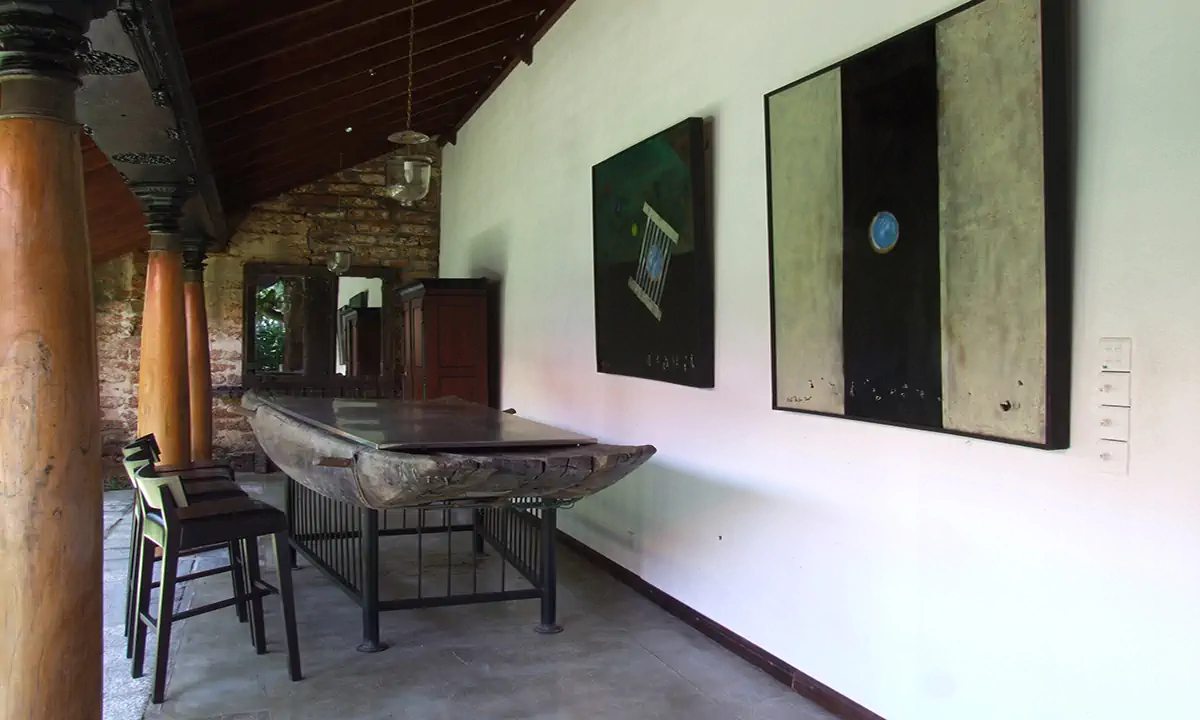 A table made from an old timber boat hull, with bar stools, on the verandah