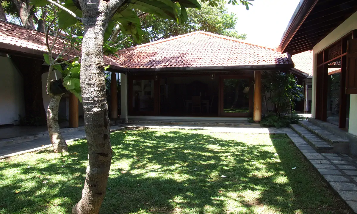 Lawn courtyard facing a clay-tiled pavilion