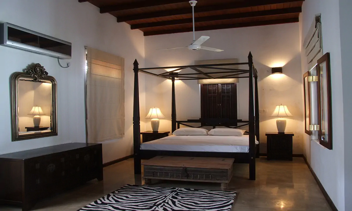 Bedroom with a four-poster bed under a timber-beamed ceiling