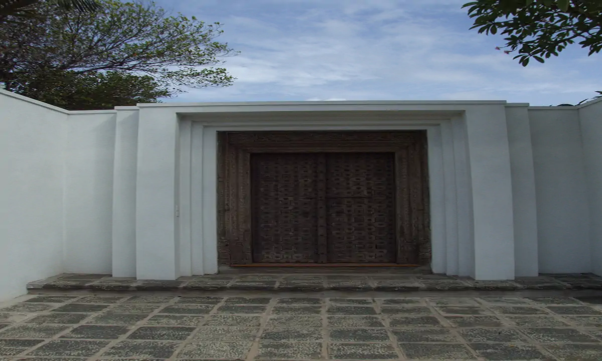 Carved timber entrance doors set in a white stepped gateway