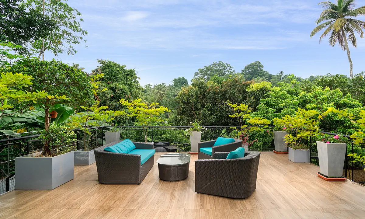 Roof terrace with rattan seating and planters, looking over the treetops
