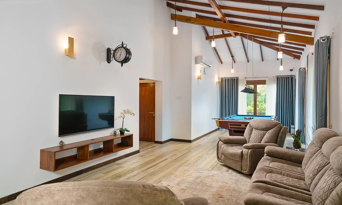 Upstairs family room under a pitched, timber-beamed ceiling, with a pool table beyond