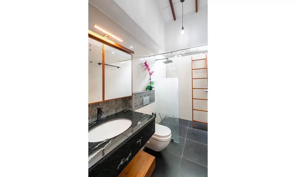 Bathroom with a black granite vanity, a timber-framed mirror and a walk-in shower