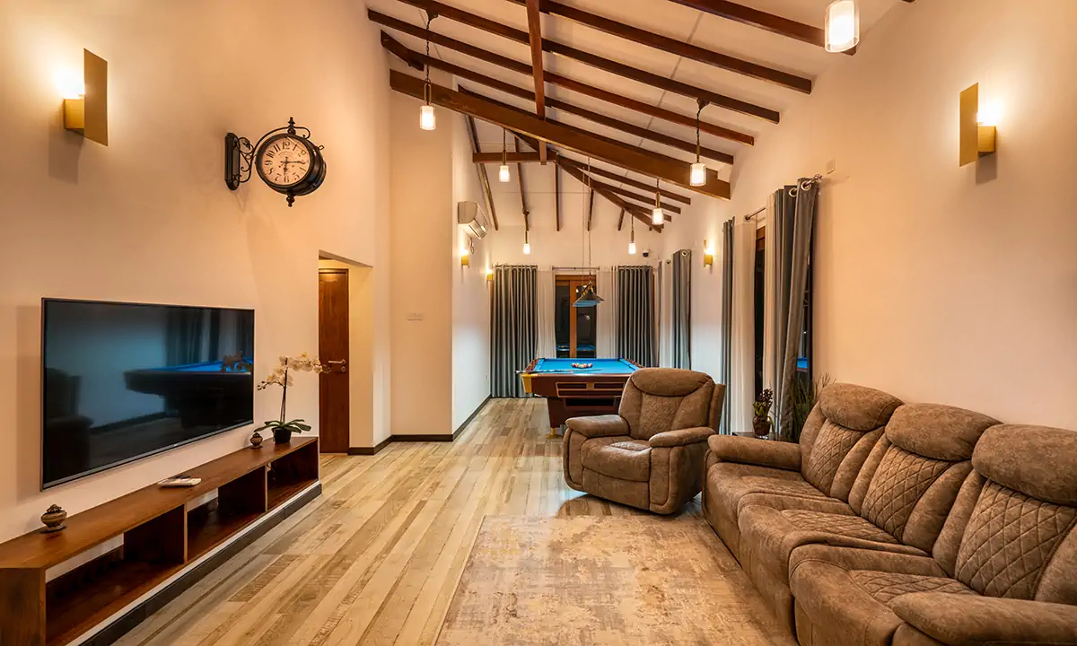 Family room with brown sofas under the raked, timber-beamed ceiling