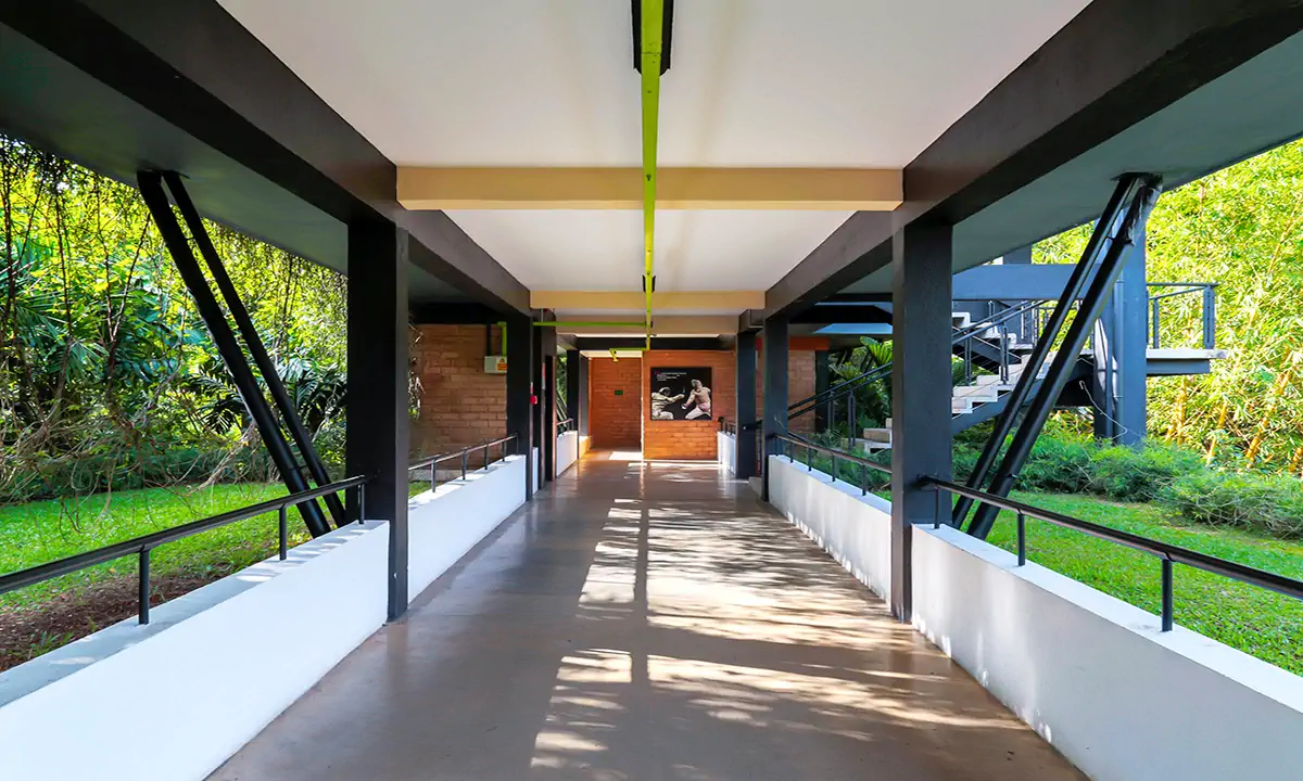 Covered bridge between buildings, open to the greenery on both sides