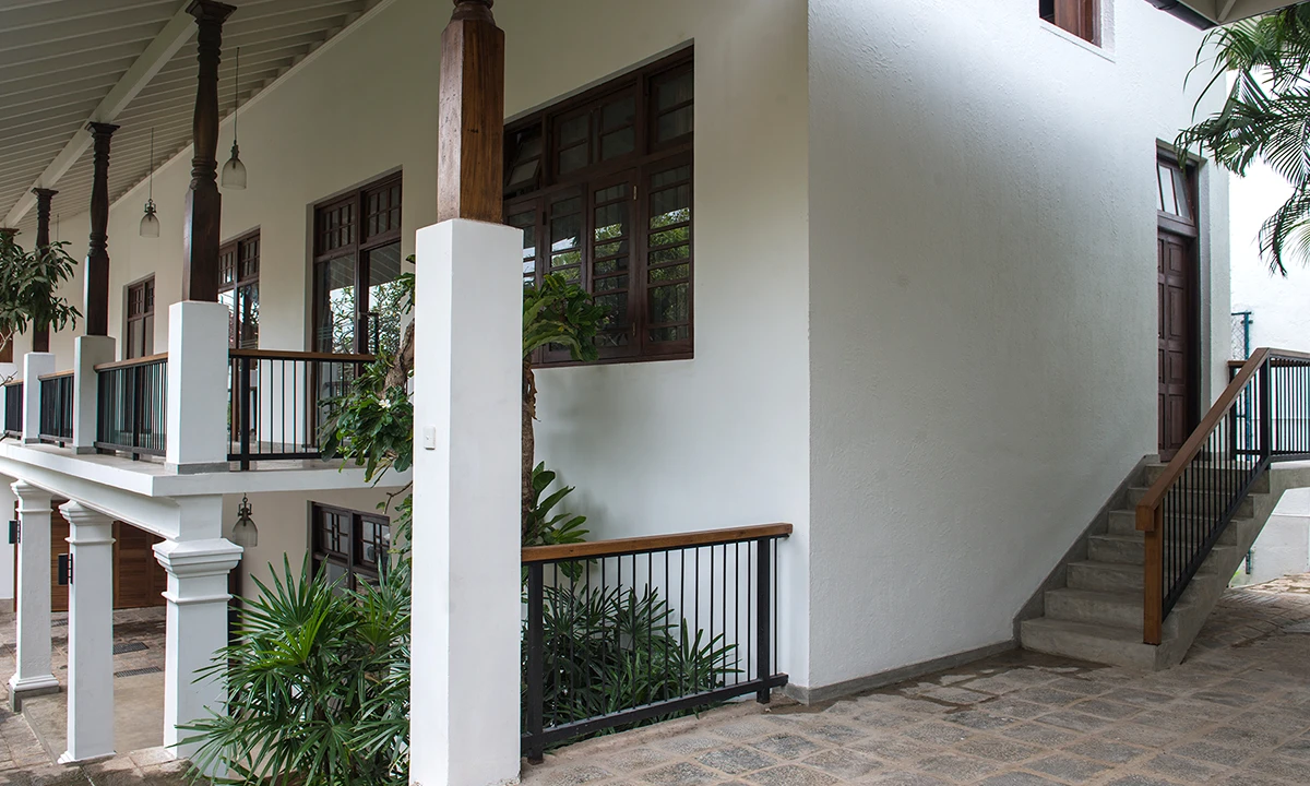 Villa 82: a stair rising past white columns to the first-floor verandah