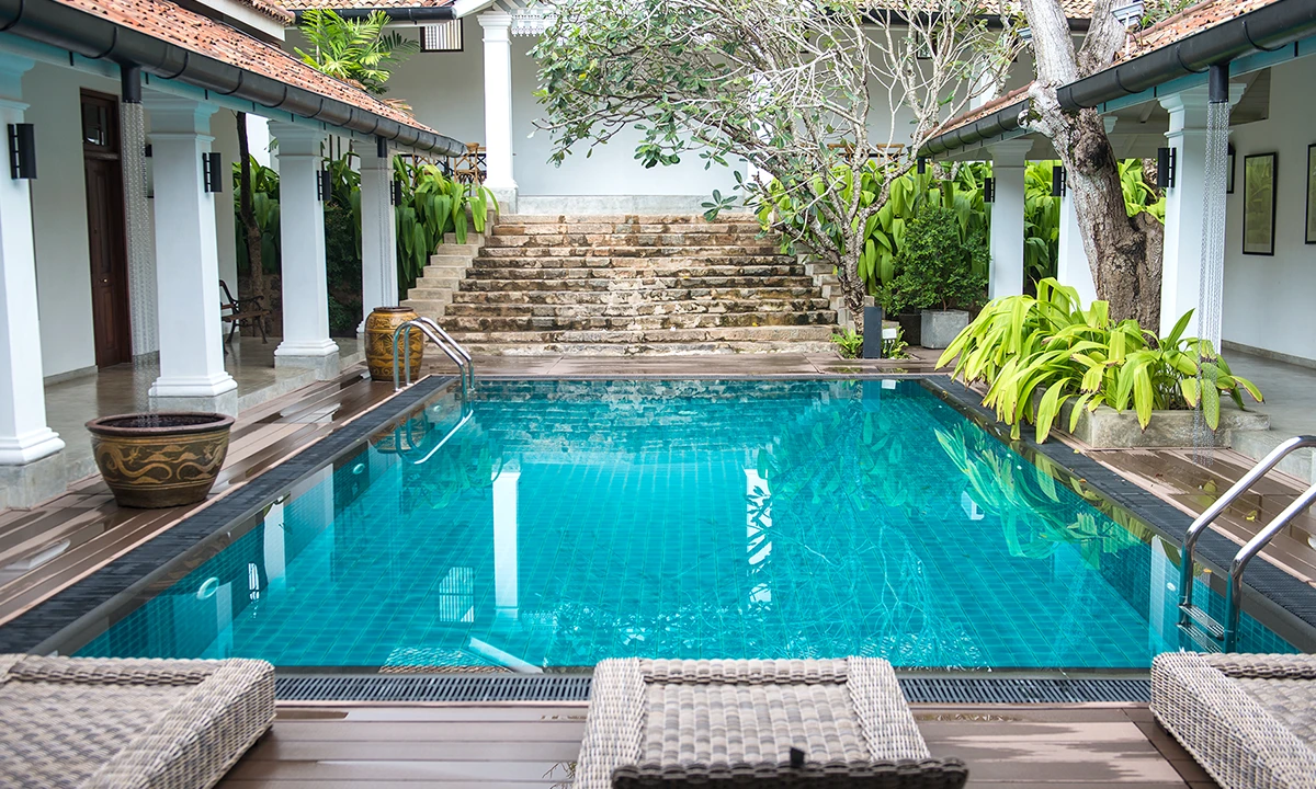 Courtyard pool with wide stone steps rising at the far end, framed by tiled verandahs