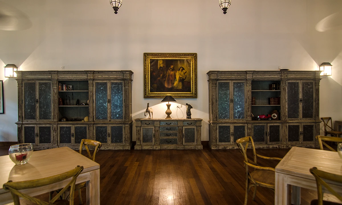 Dining room with glass-fronted cabinets either side of an oil painting