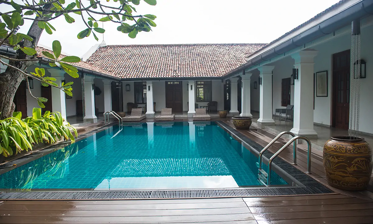 Pool courtyard surrounded by clay-tiled verandahs on white columns
