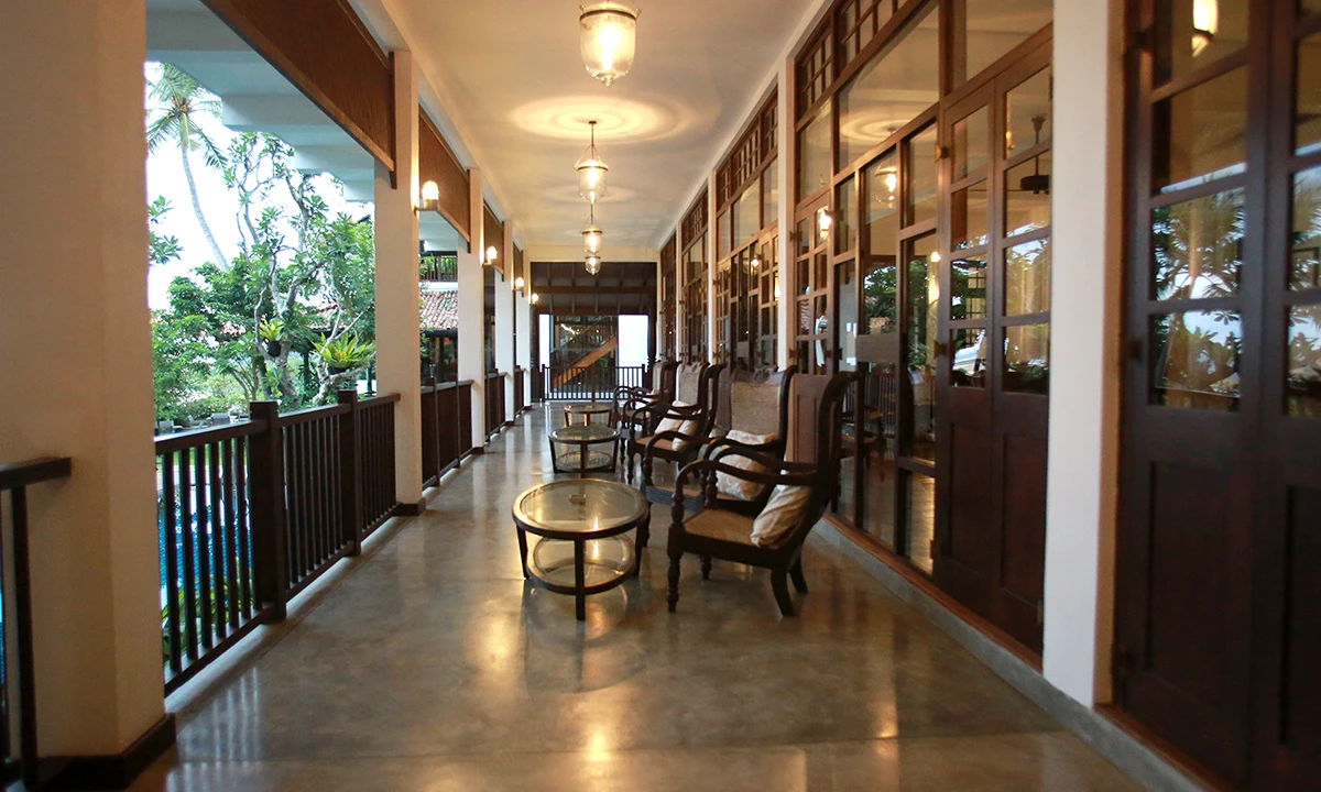 Upper verandah at dusk, with timber-framed glass doors and a timber balustrade