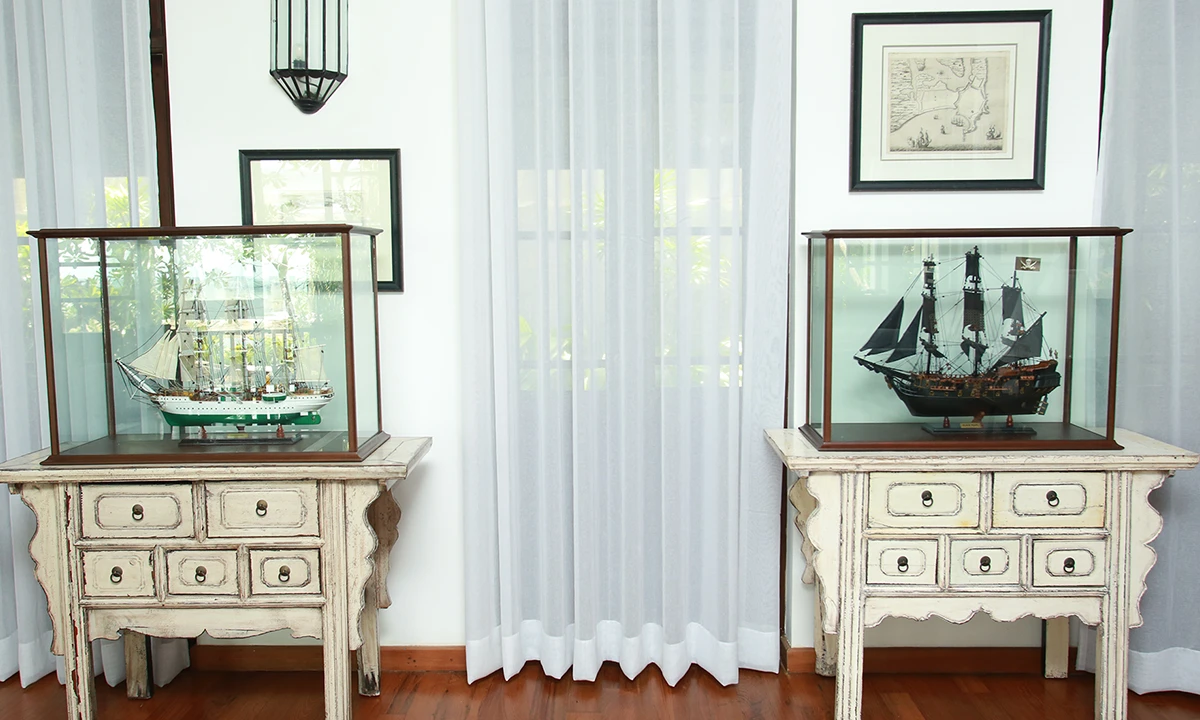 Model ships in glass cases on two painted cabinets